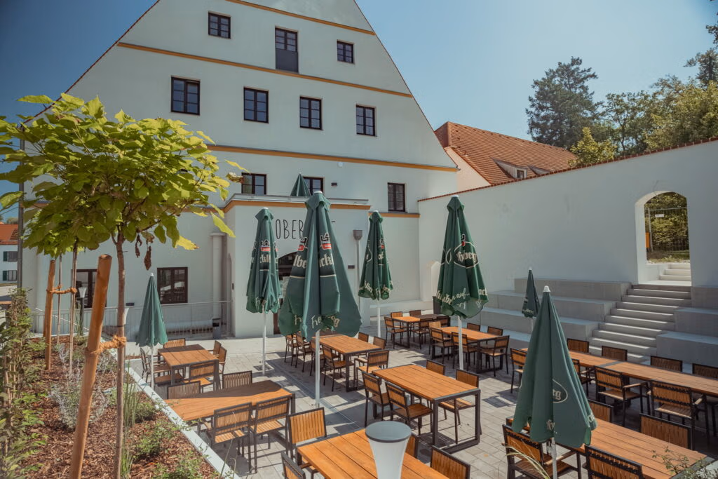 Eiin Biergarten vor einer Ferienwohnanlage in Eggenfelden