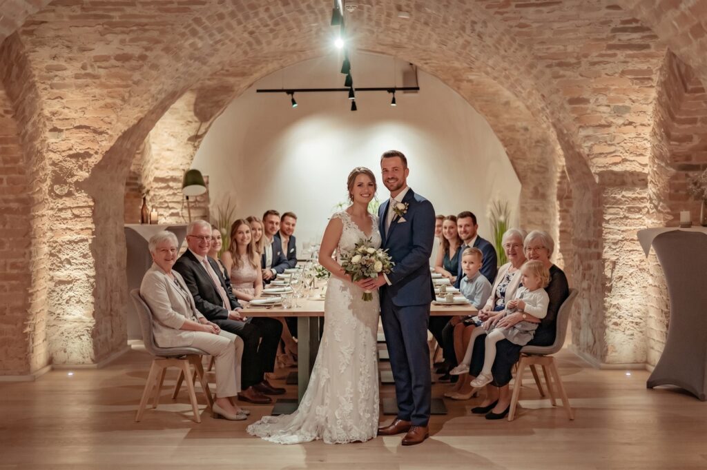 Eine Hochzeitsgesellschaft feiert eine Hochzeit in einem rustikalen Gewölbekeller
